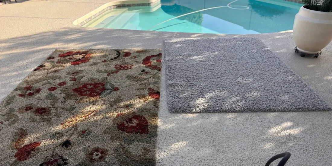 Two area rugs laid out to dry on a patio after cleaning